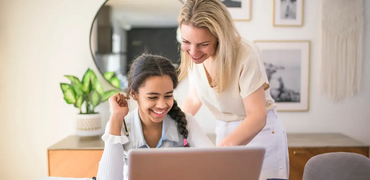 Mother and her daughter working together with thier laptop at home